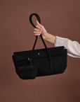 Woman carrying Rico Rinaldi Mendy Black shoulder bag with detachable mini pouch, premium East-West work handbag in crocodile embossed vegan leather