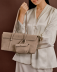 Model wearing Rico Rinaldi Mendy Latte shoulder bag, minimalist East-West women's handbag for office, commuting and daily use