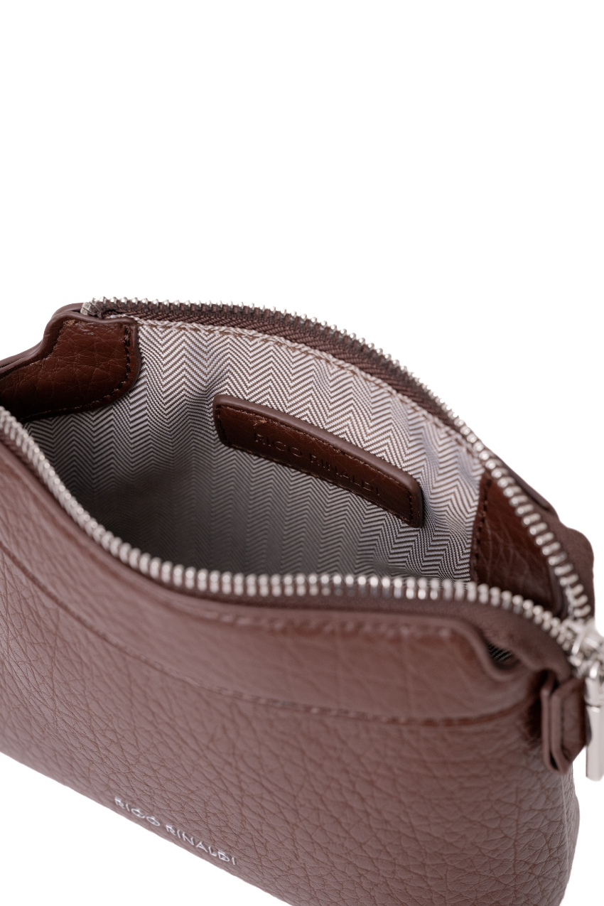 Close-up of a brown textured leather pouch with a silver zipper, showing the interior lining and a small interior label, on a white background. Rico Rinaldi Norri Women's Convertible Shoulder and Crossbody Bag with Detachable Pouch.