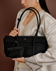 Model wearing Rico Rinaldi Mendy Black East-West shoulder bag, minimalist crocodile embossed vegan leather office handbag for women