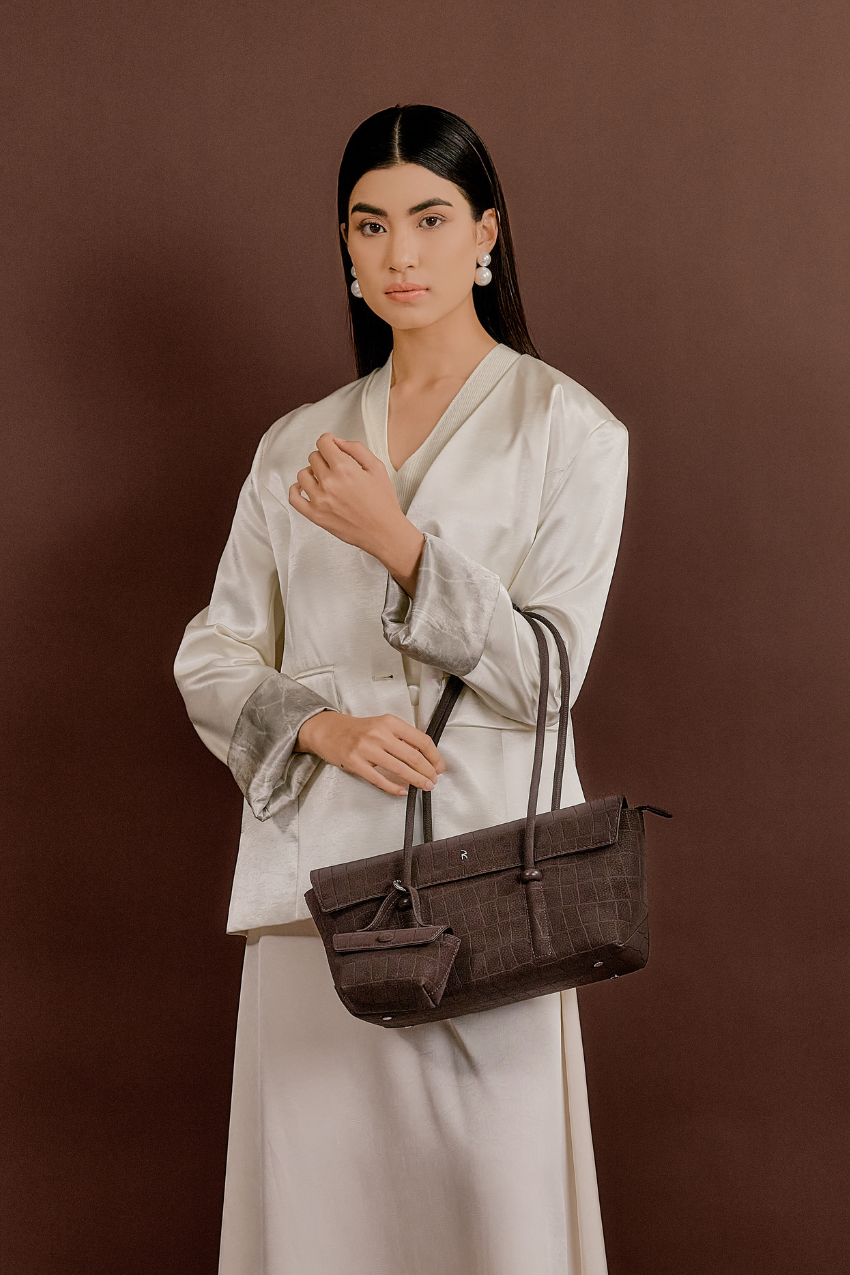 Model wearing Rico Rinaldi Mendy Dark Coffee shoulder bag, elegant East-West women's handbag for work, office and everyday wear