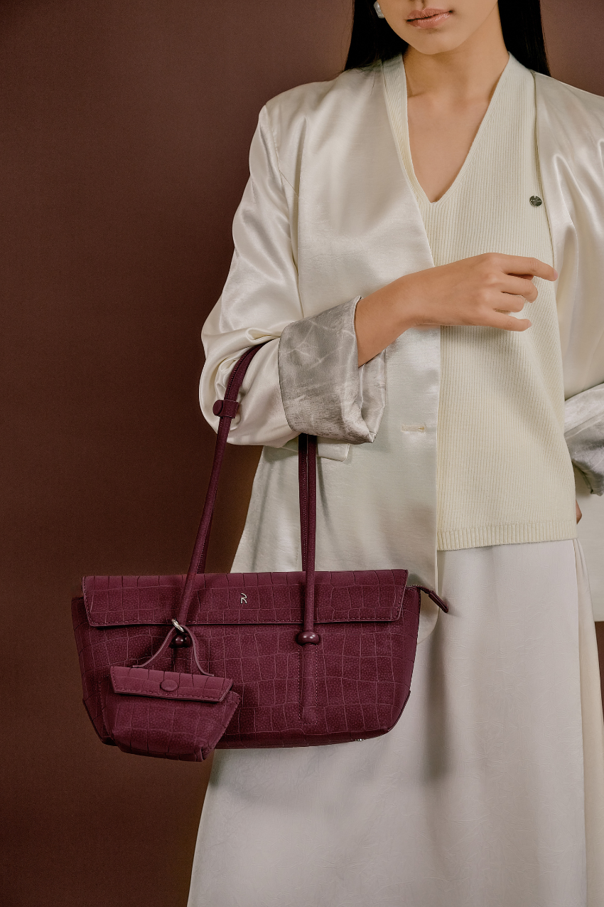 Model wearing Rico Rinaldi Mendy Deep Maroon shoulder bag, minimalist East-West women's handbag for office and everyday use