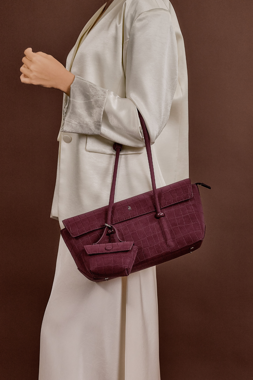 Model carrying Rico Rinaldi Mendy Deep Maroon shoulder bag featuring a spacious interior, secure zip closure and detachable mini pouch